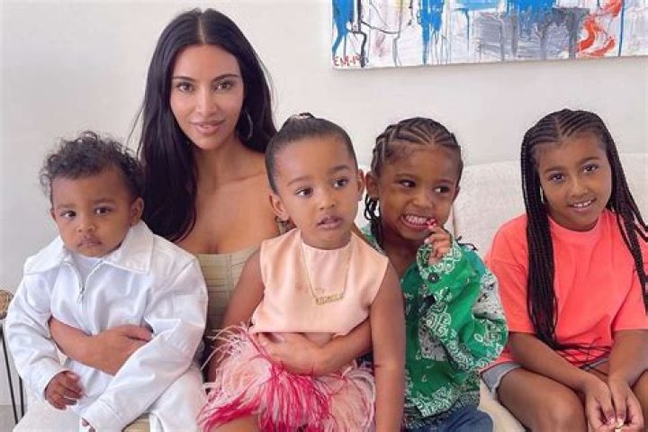 Kim Kardashian and her four children on the beach wearing matching silver swimsuits