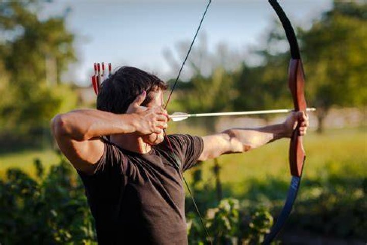 Man Firing Bow And Arrow